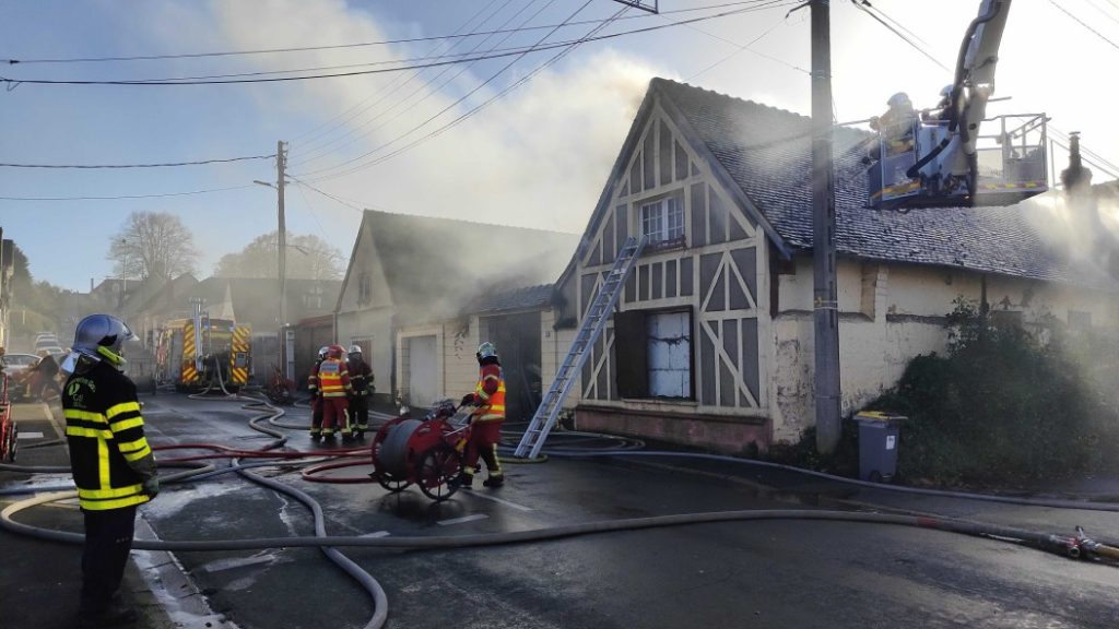 Photo of the street under the smoke with firefighters working.