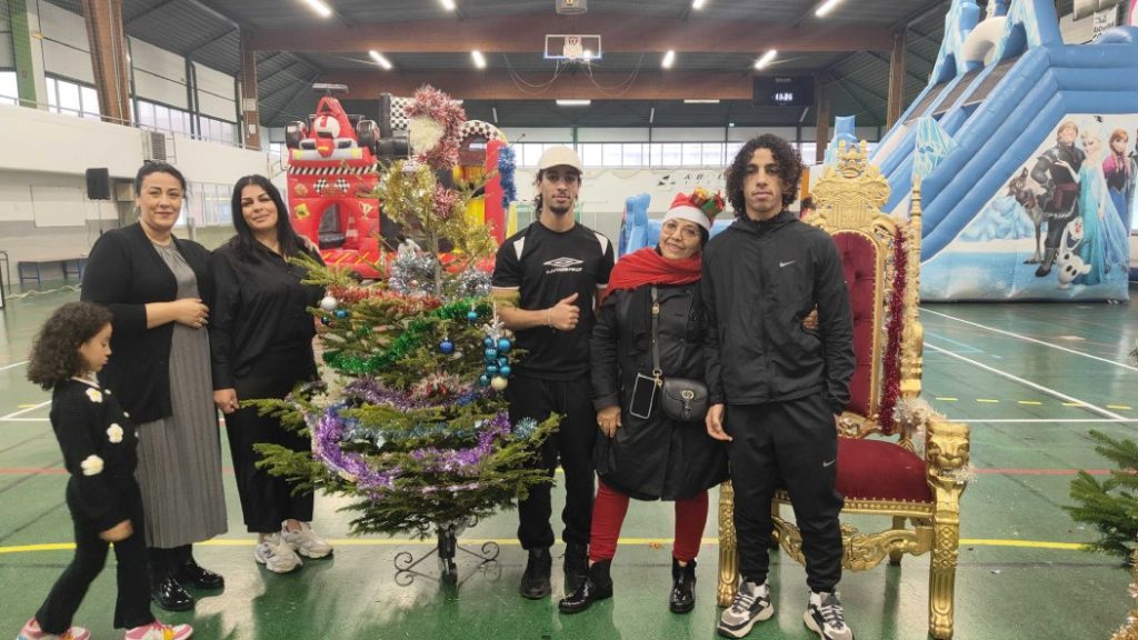 Photo of the few organizers around Santa's chair in the gymnasium.