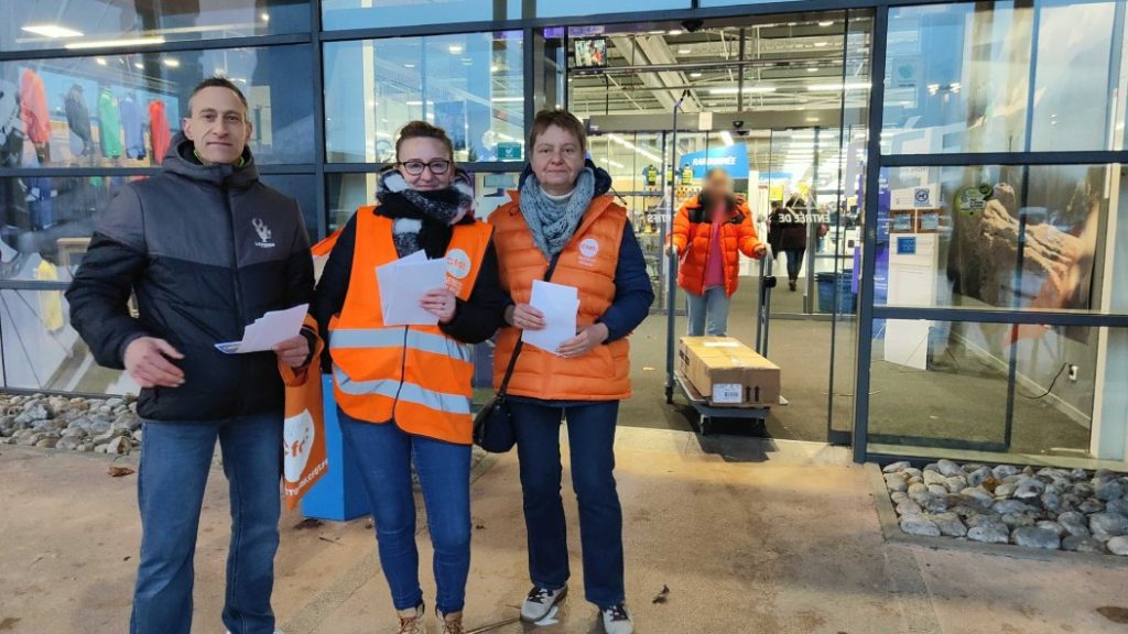 Photo of three union representatives at the entrance to Décathlon Beauvais.