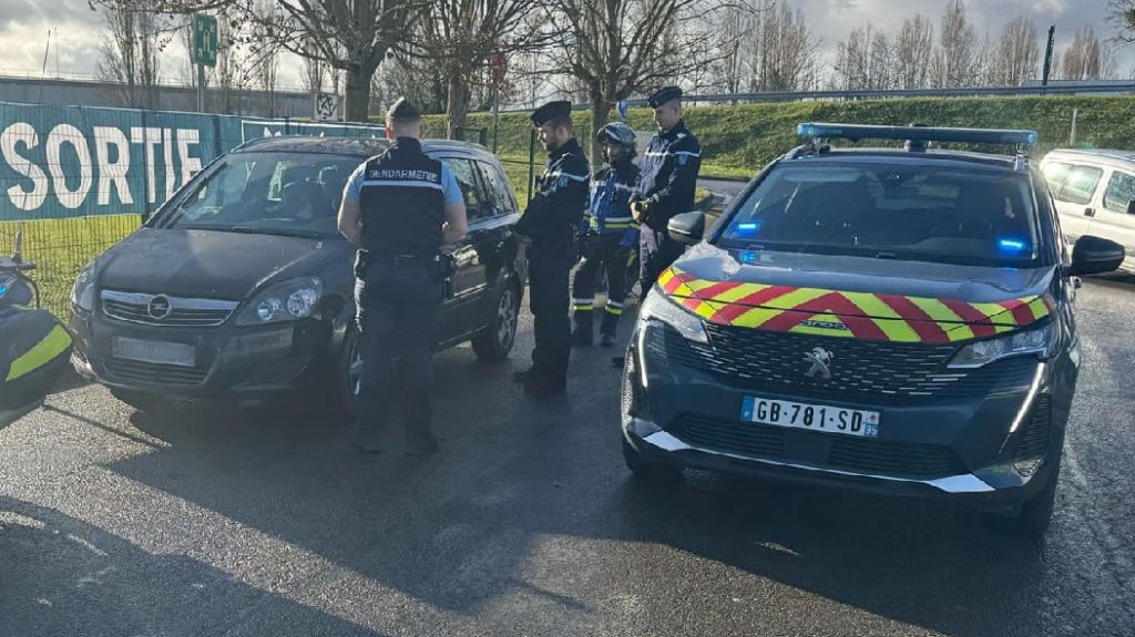 Photo of the gendarmes speaking with the people on board the black Opel Zafira.