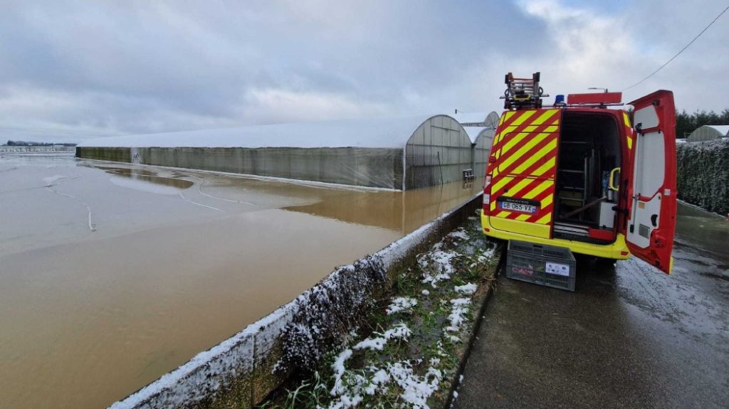 Photo of the flooding around the Dekester greenhouses in Grandvilliers. We see an open fire engine in the photo.