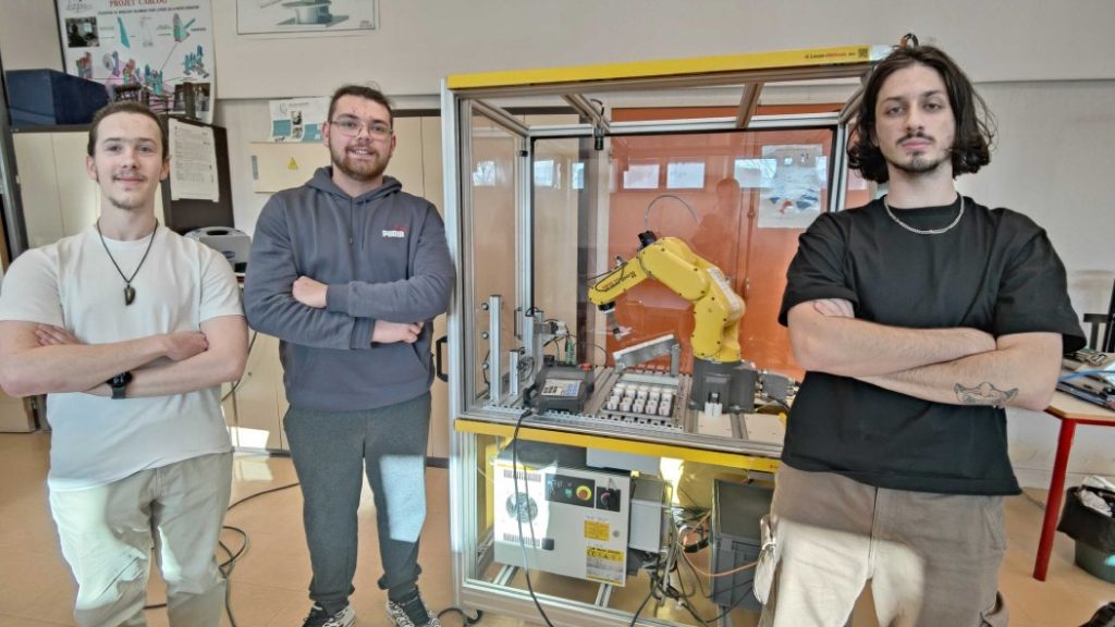 Florent, Aurélien and Nathan next to a Fanuc robotic arm in the Paul-Langevin high school in Beauvais.