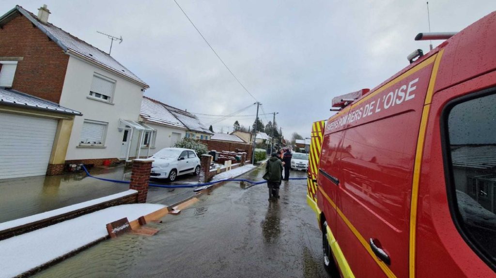 Photo of firefighters pumping water from the cellar of a house near Grandvilliers.