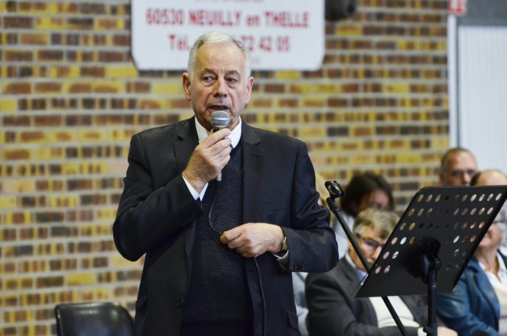 Photo of Bernard Onclercq with microphone in hand during his vows.